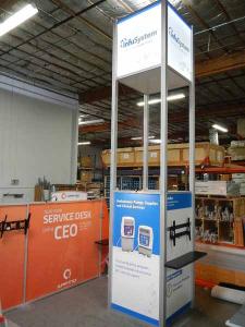 RENTAL:  Custom 20 ft. High Tower with SEG LED Backlit and Sintra Infill Graphics. Includes Locking Door, Large Monitor, and Black Laminated Shelf -- Image 1