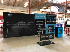 Symphony SYK-2004 Inline Display with SEG Fabric Graphics, Literature Trays, Backwall Workstation with Wireless Charging Pads, SYM-412 Counter with Shelves, and SYM-406 Counter with Locking Storage