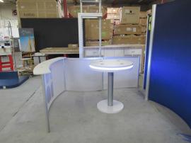 Modified ECO-2018 Sustainable Exhibit with Tension Fabric Graphics, Reception Counter, Backwall Counter with Locking Storage, Large Monitor Mount, Privacy Wall, and MOD-1453 Charging Table with LED Perimeter Lights. Reconfigures to 10', 20', and 30' Inlin